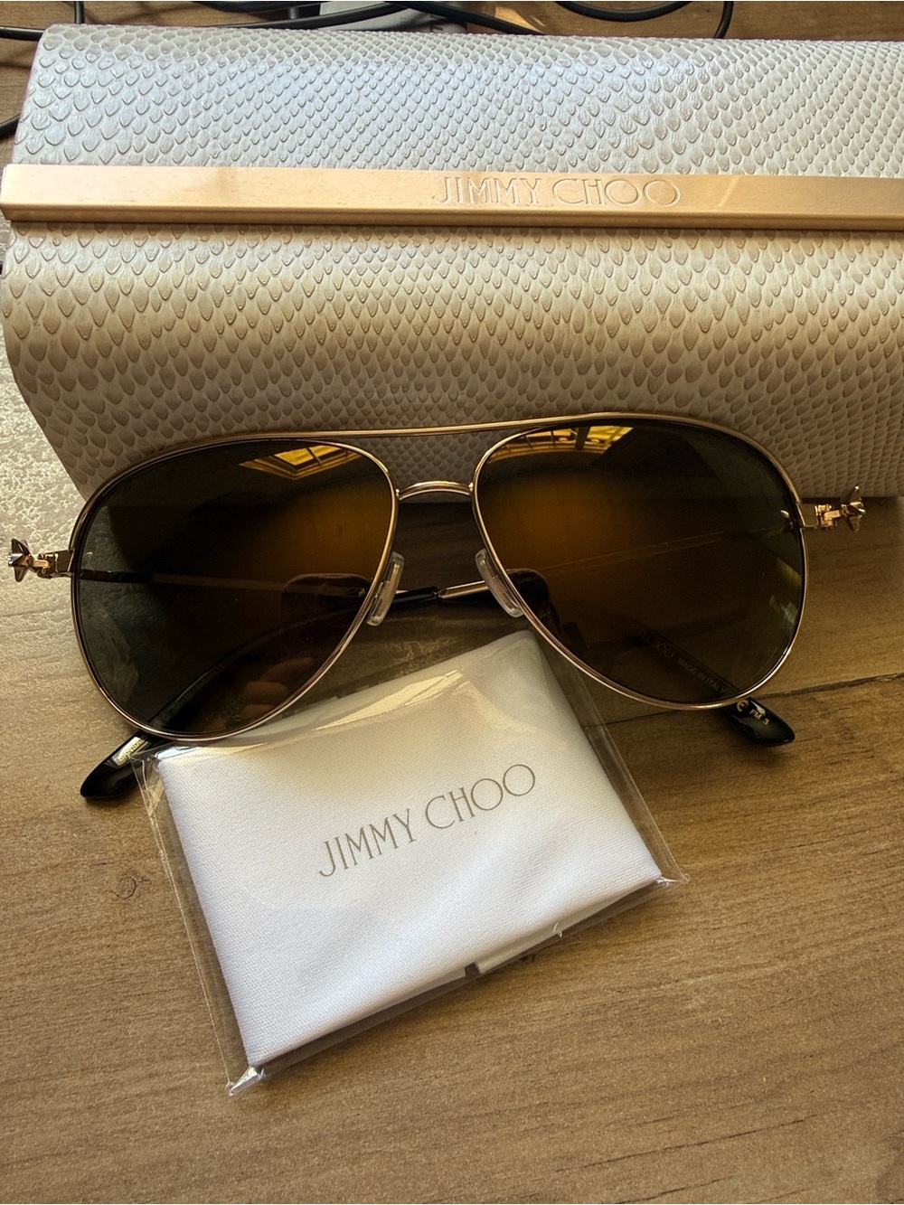 Jimmy Choo sunglasses. Cream Textured Clutch with Gold Bar
